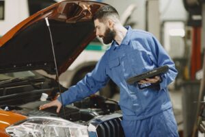 Mecânico examinando o motor de um carro com o capô aberto