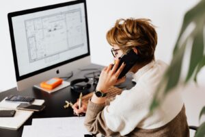 Mulher ao telefone fazendo anotações sobre a conversa