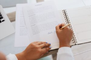 Pessoa assinando um contrato sobre uma mesa de escritório