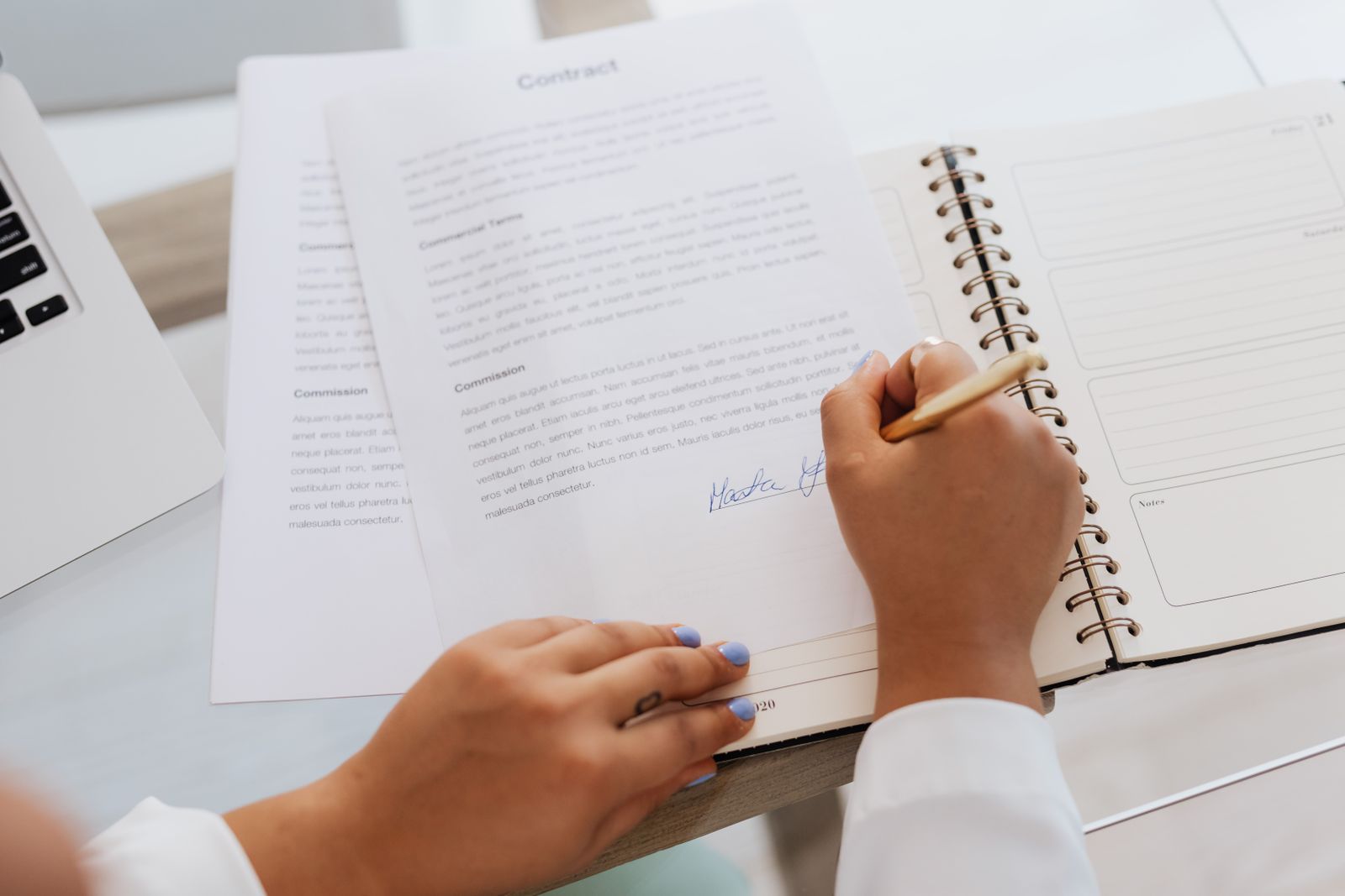 Pessoa assinando um contrato sobre uma mesa de escritório