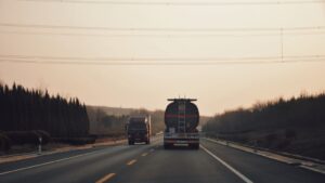 Caminhões trafegando em rodovia ao entardecer