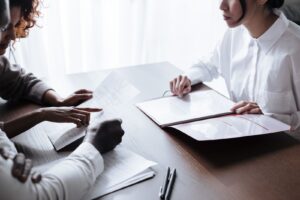 Pessoas reunidas a uma mesa analisando documentos